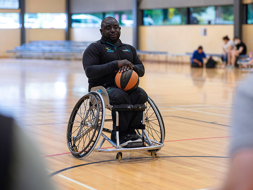 Man in wheelchair holding basketball
